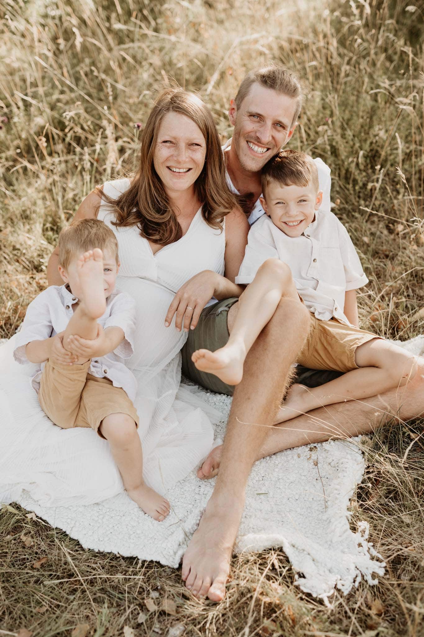 Familienfoto in einer Wiese mit weißer Decke