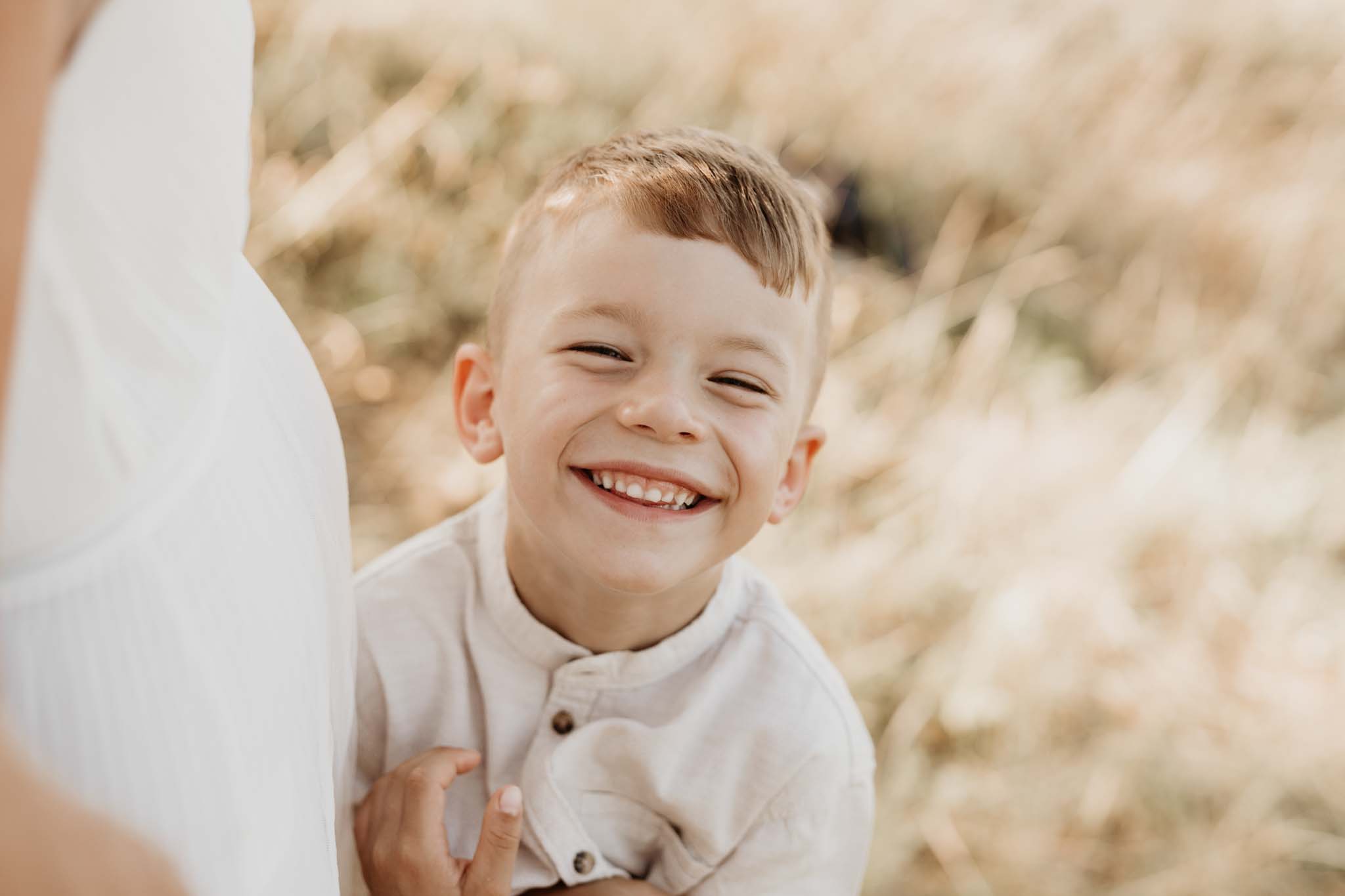 Portrait von grinsenden Jungen und Babybauch von Mama