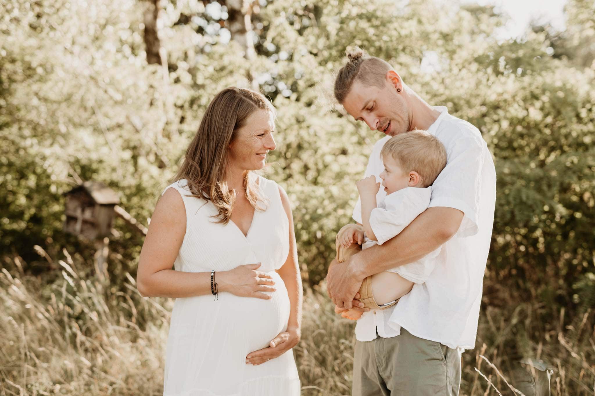 Familie beim Babybauch-Shooting im Freien