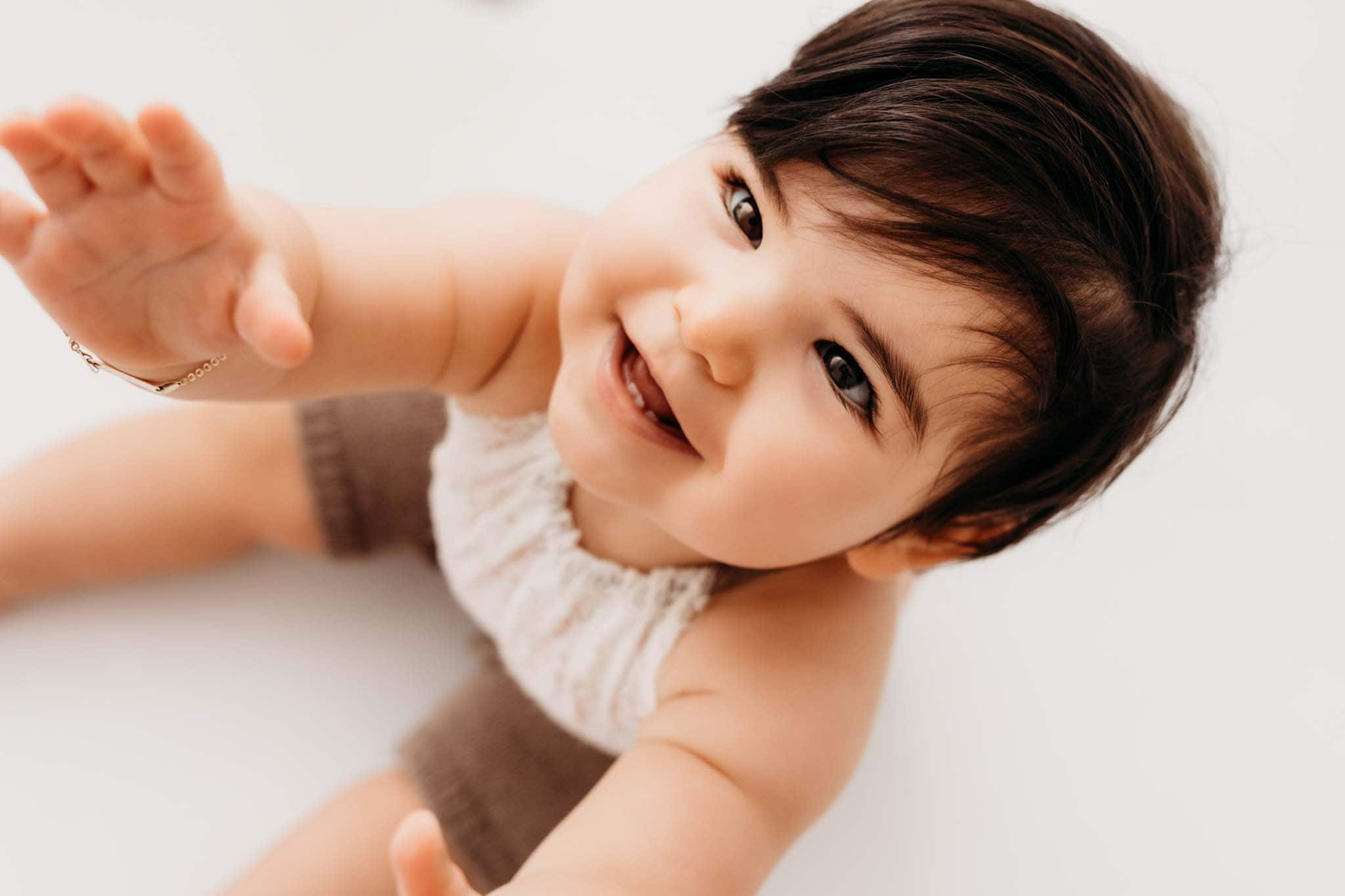 Lachendes Baby Portrait beim Shooting München Baby greift zur Kamera und lacht