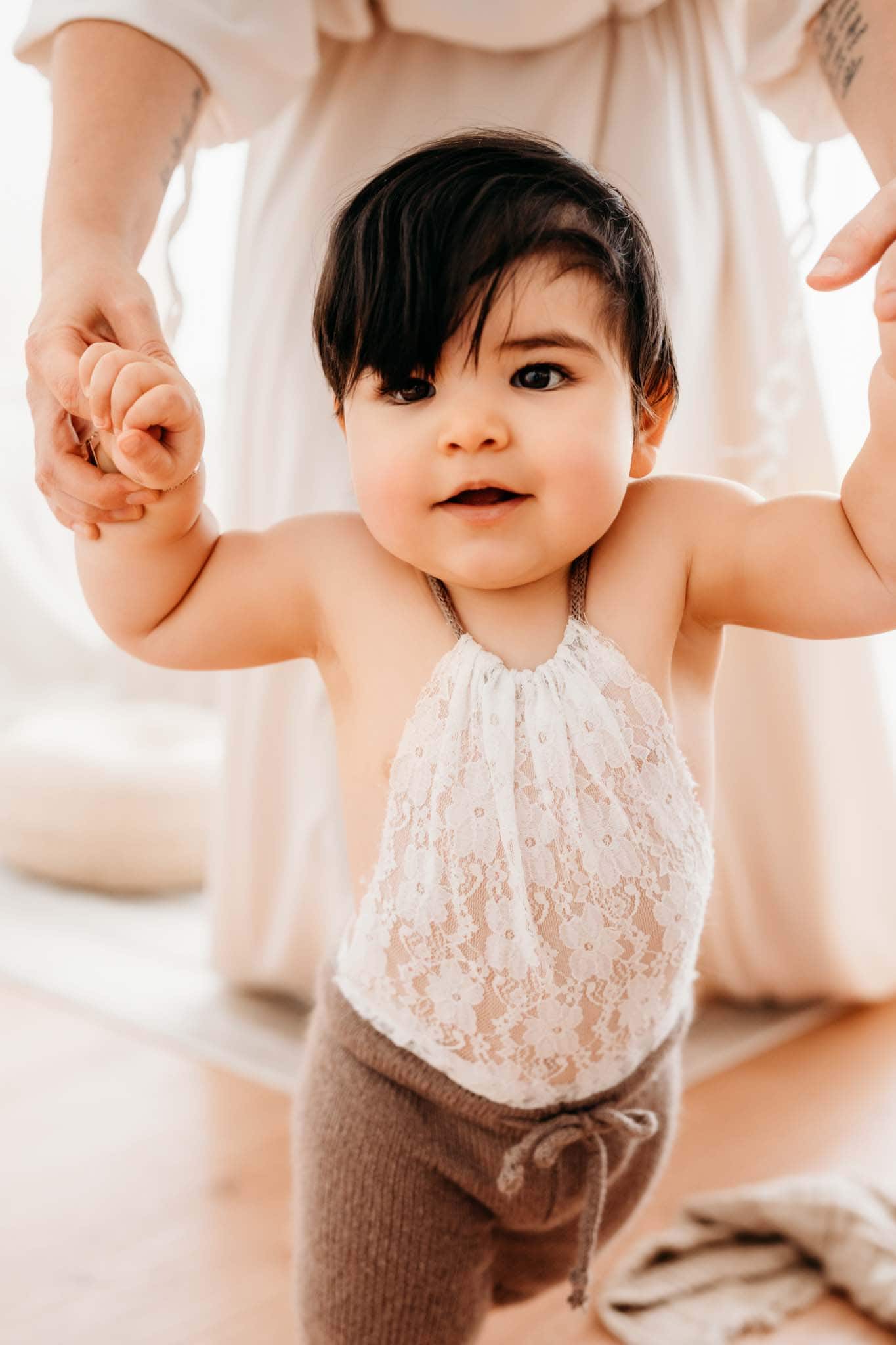 Baby lernt an Mamas Händen laufen