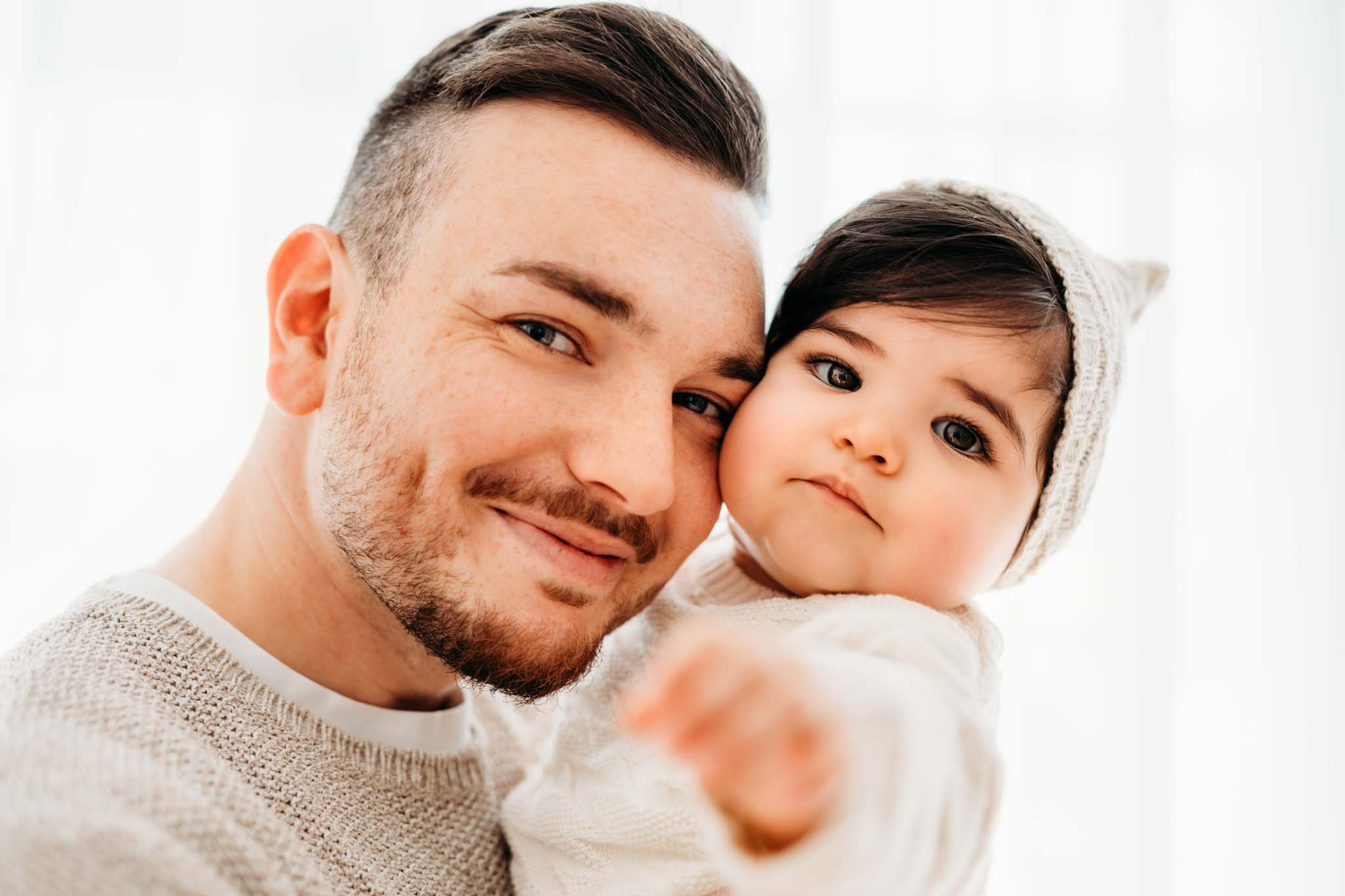 Beim Babyshooting lachen Papa und Baby in Kamera Papa und Baby lachen in Kamera