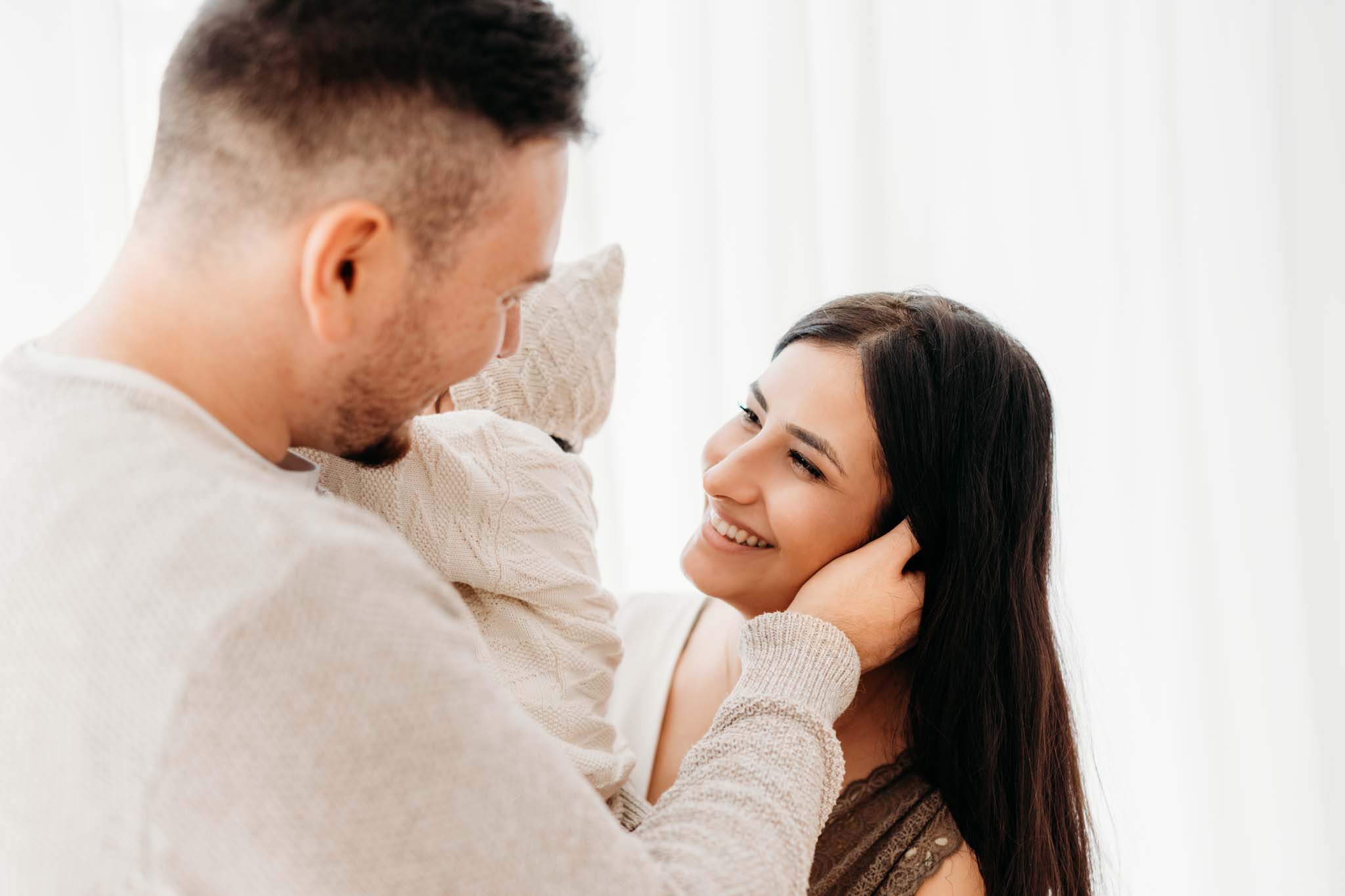 Babyshooting München: Papa fasst zärtlich Frau um den Nacken Papa fasst zärtlich Frau um den Nacken