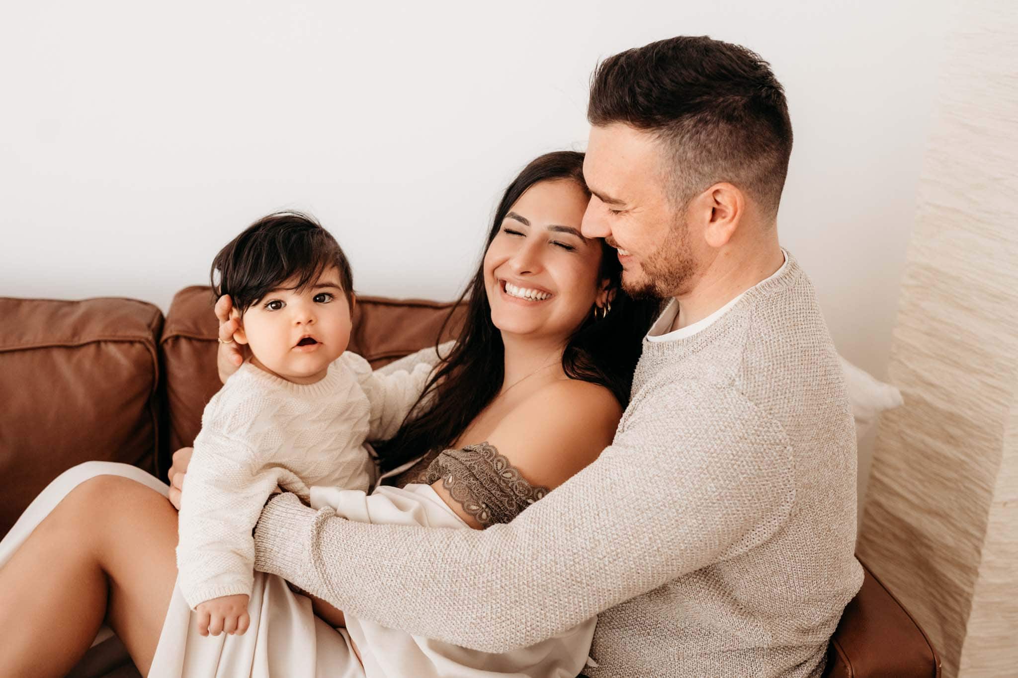Kuschelnde Familie auf Couch beim Babyshooting München Familie kuschelt auf Couch