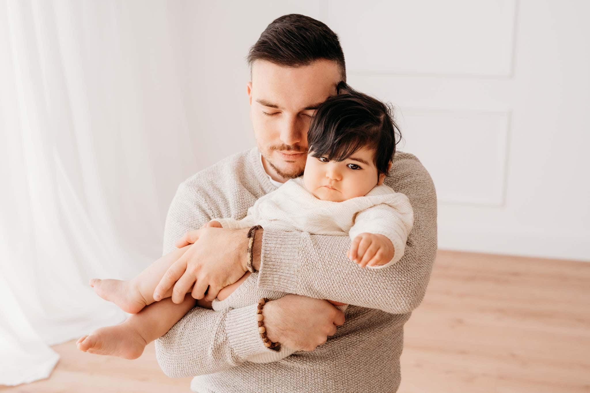 Papa tröstet Baby am Arm beim Baby Fotoshooting München Papa tröstet Baby am Arm