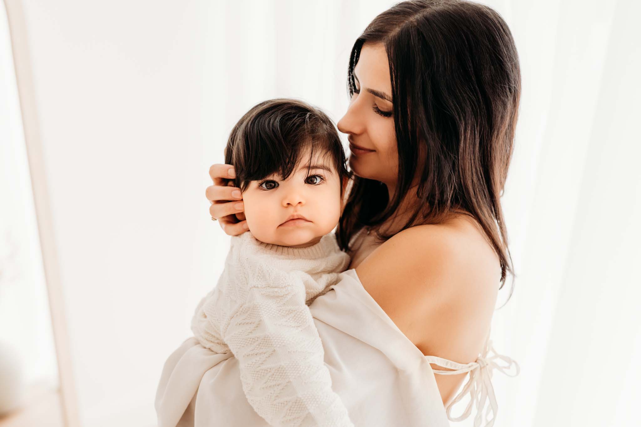 Mama küsst ihr Baby und streichelt es am Kopf