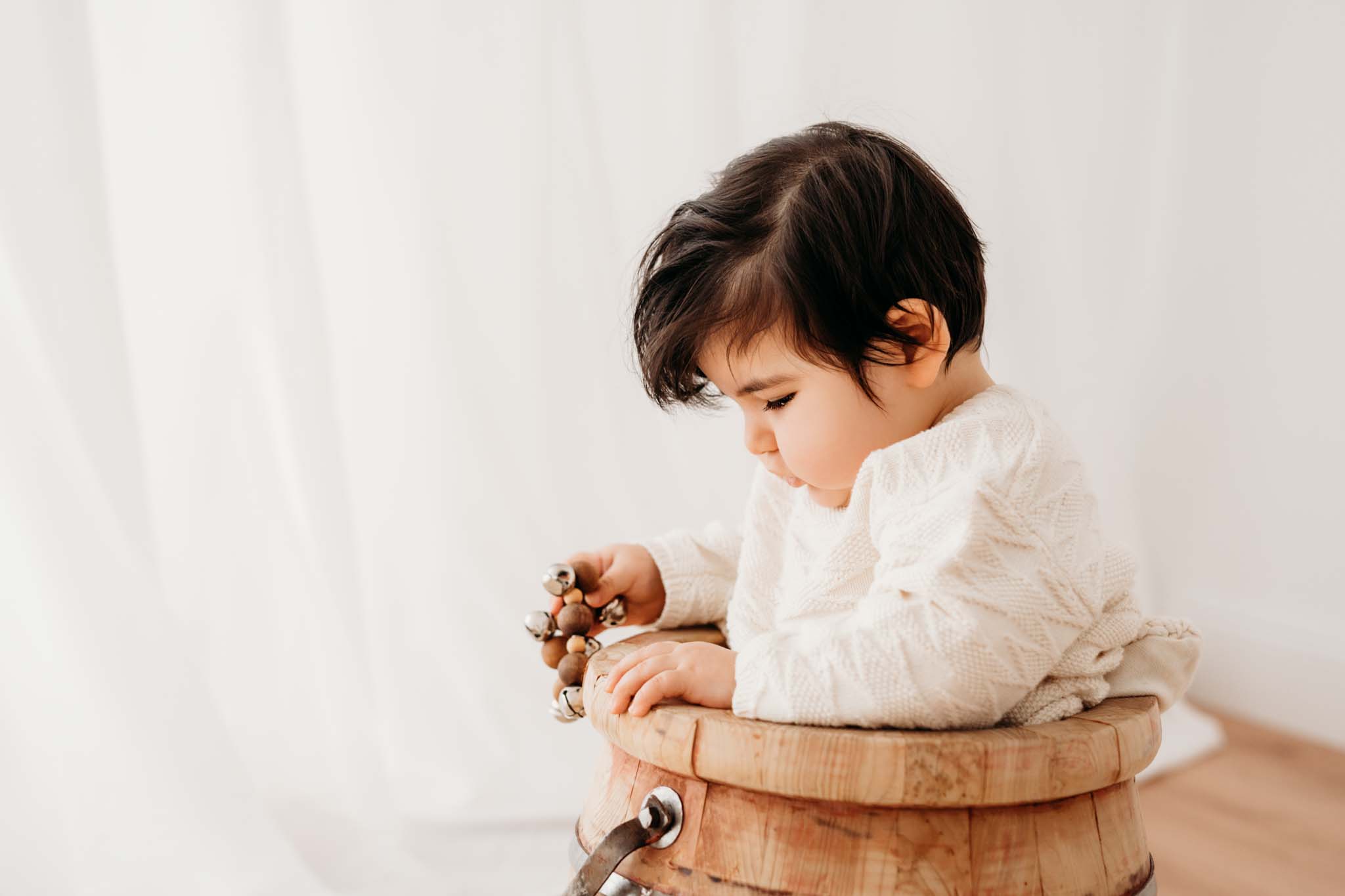 Baby spielt in Babyfotografie München konzentriert mit Eimer Baby spielt konzentriert mit Eimer