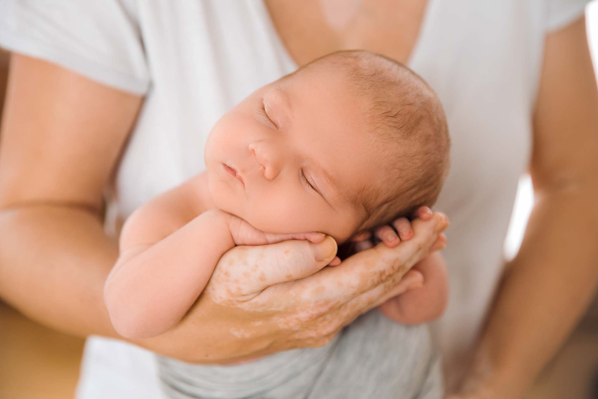 Familienfotografin München: Neugeborenen-shooting mit Familie kuschelnd am Flokati