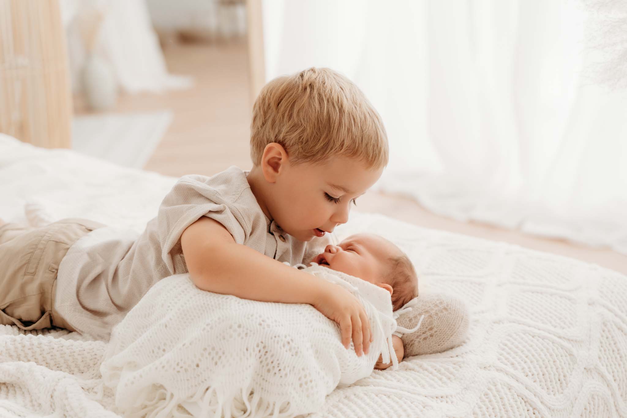 Familienfotografin München Geschwisterkind kümmert sich um Baby