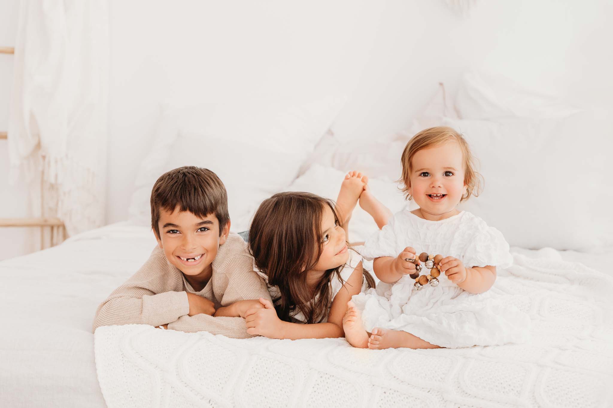 Foto von Geschwisterkinder beim Fotoshooting am Bett