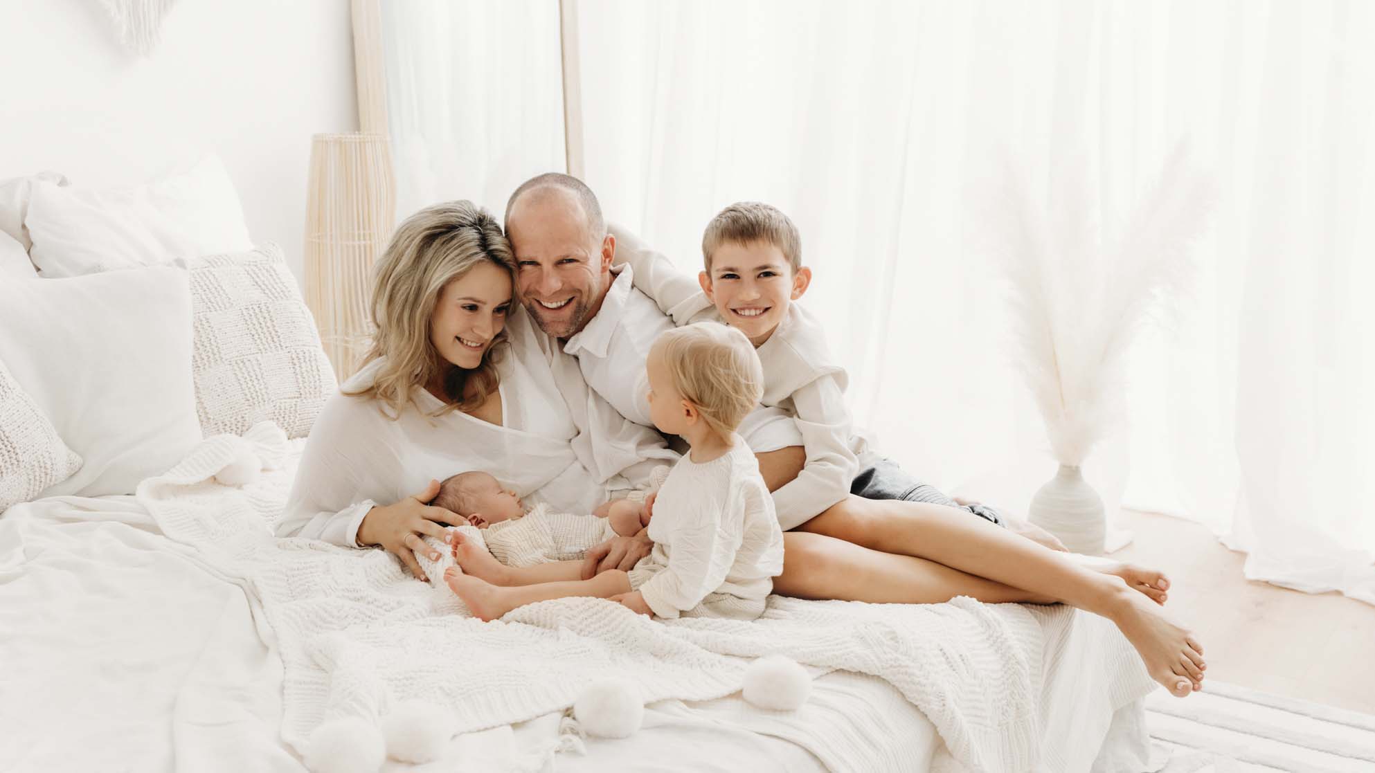 Familie am Bett beim Newborn-Shooting