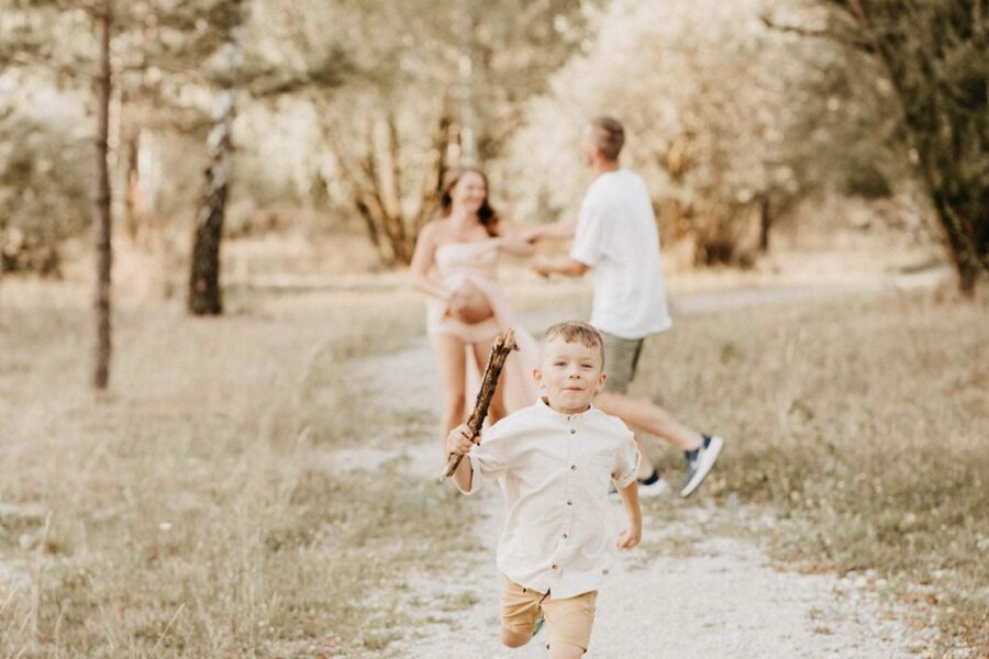 Eltern fangen sich beim Babybauchshooting im Freien