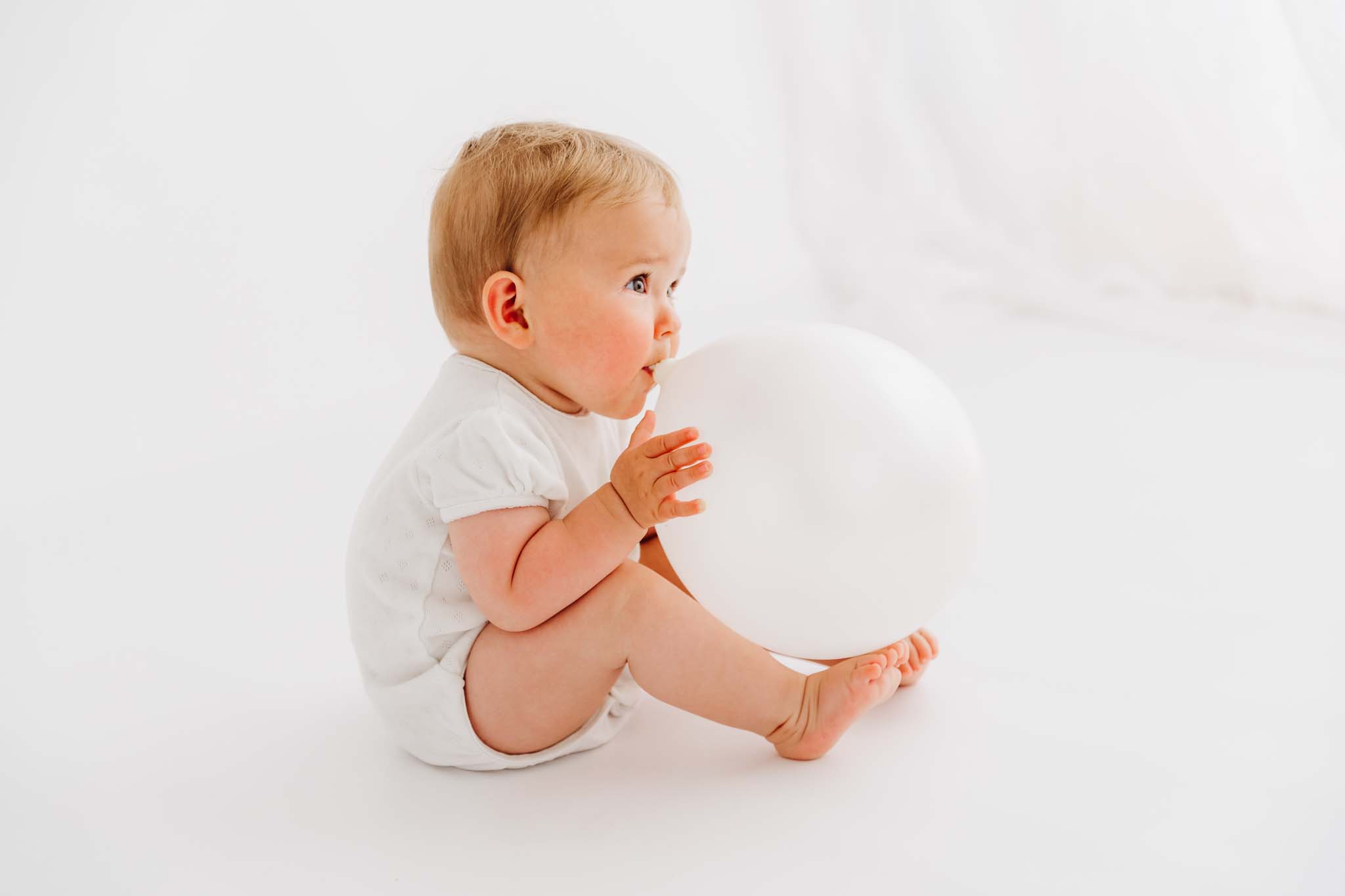 Baby blast Luftballon auf beim Babyshooting