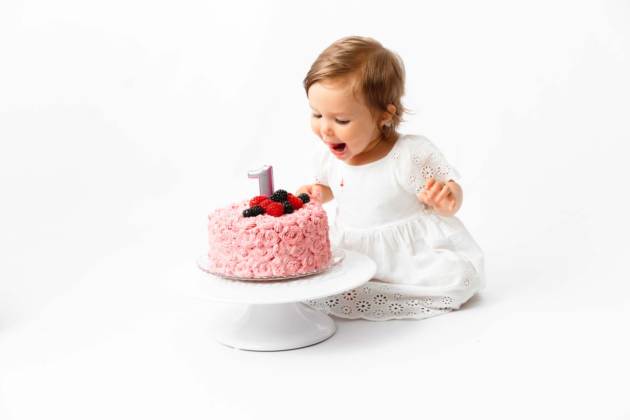 Mädchen isst Torte zum ersten Geburtstag
