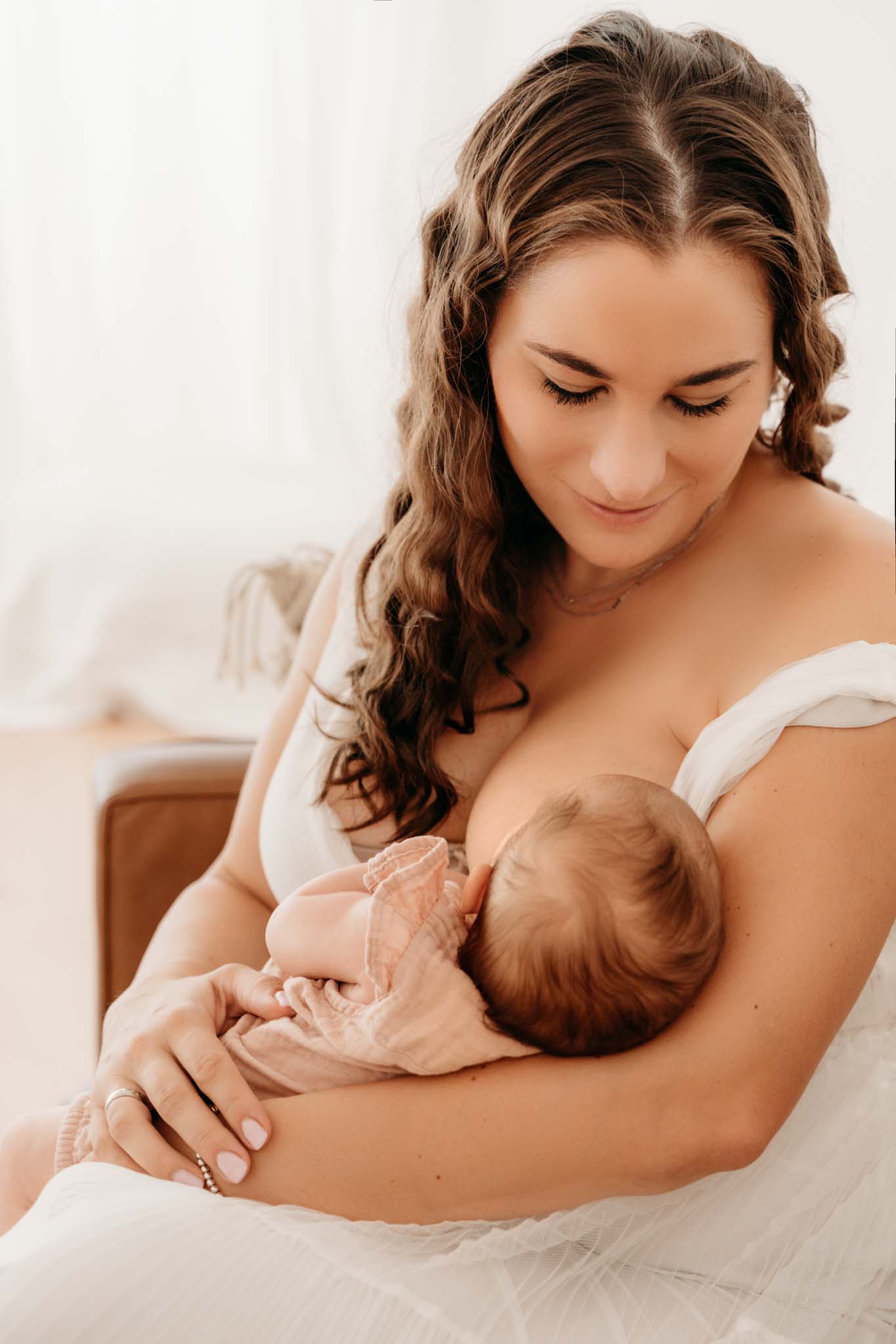 Emotionale Neugeborenenfotografie beim Stillen Mama stillt Neugeborenes in der emotionalen Neugeborenenfotografie