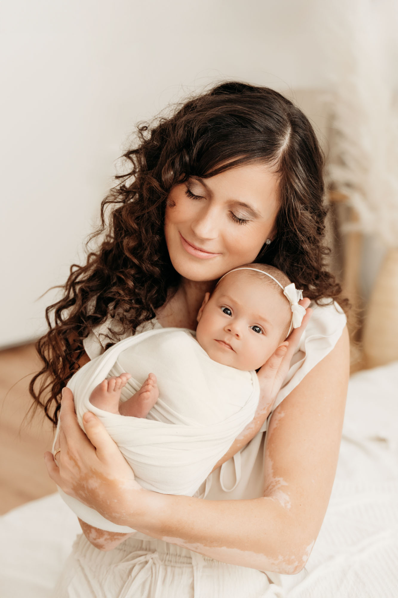 Babyfotografie Graz - Newborn mit großen wachen Augen in Mamas Armen