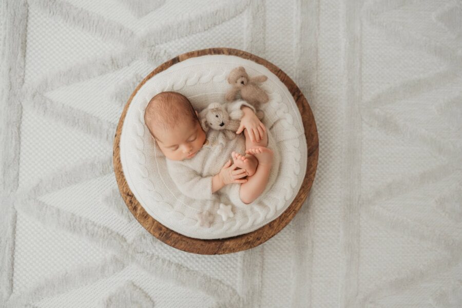 Neugeborenes in Holzschale mit Teddybären beim Fotoshooting Graz