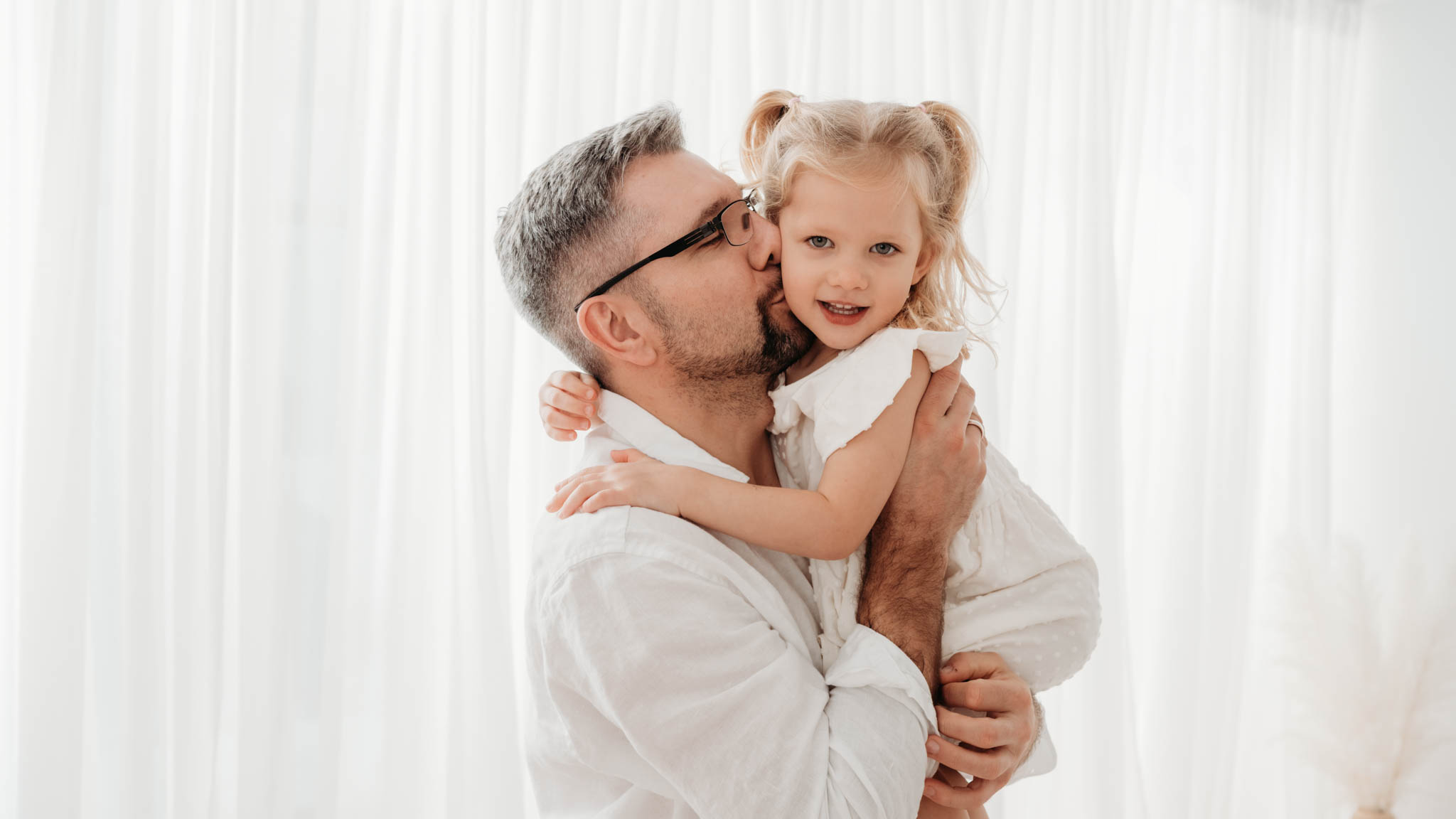 Papa schmust mit Tochter Papa küsst Tochter auf die Wange