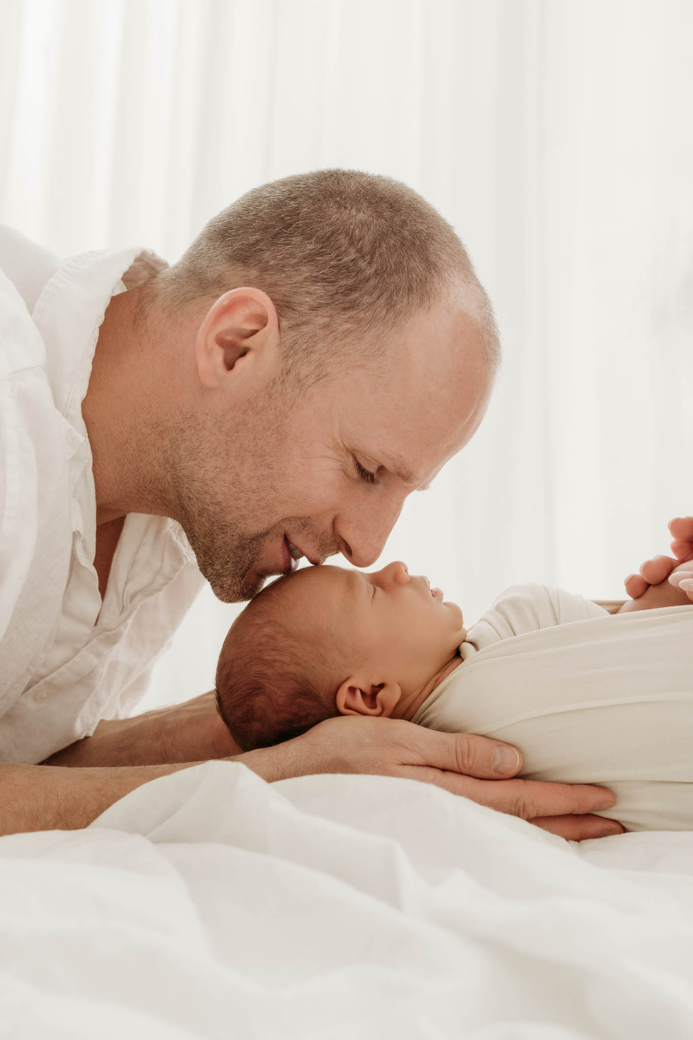 Papa küsst Babys Kopf in Nahaufnahme Papa küsst Babys Kopf in Nahaufnahme