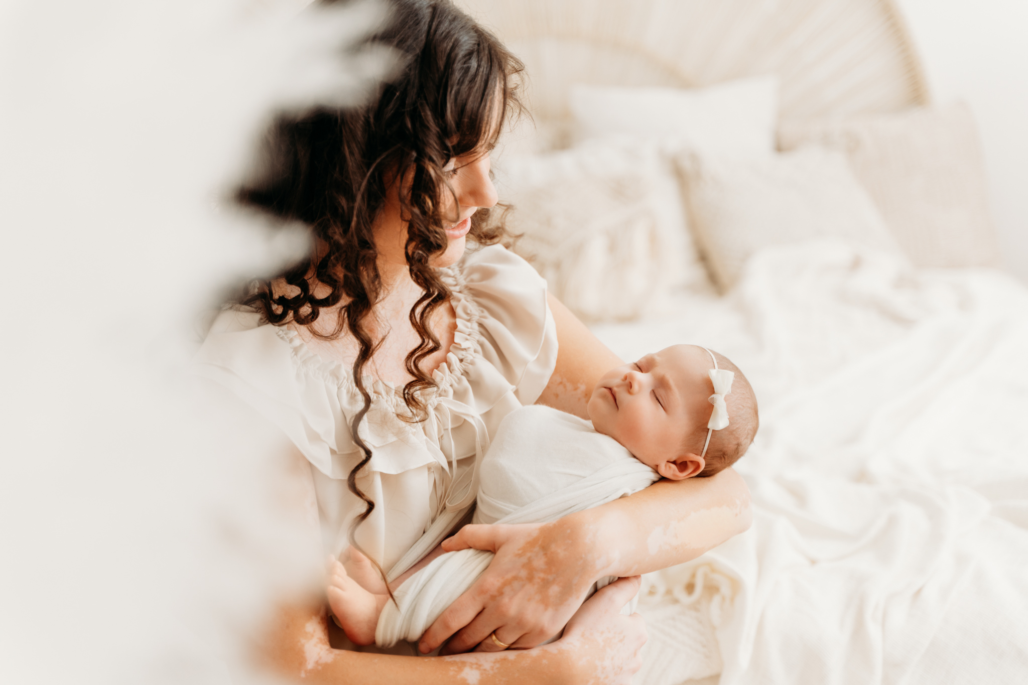 Mama kuschelt mit Baby im Arm beim Neugeborenen-Shooting Graz