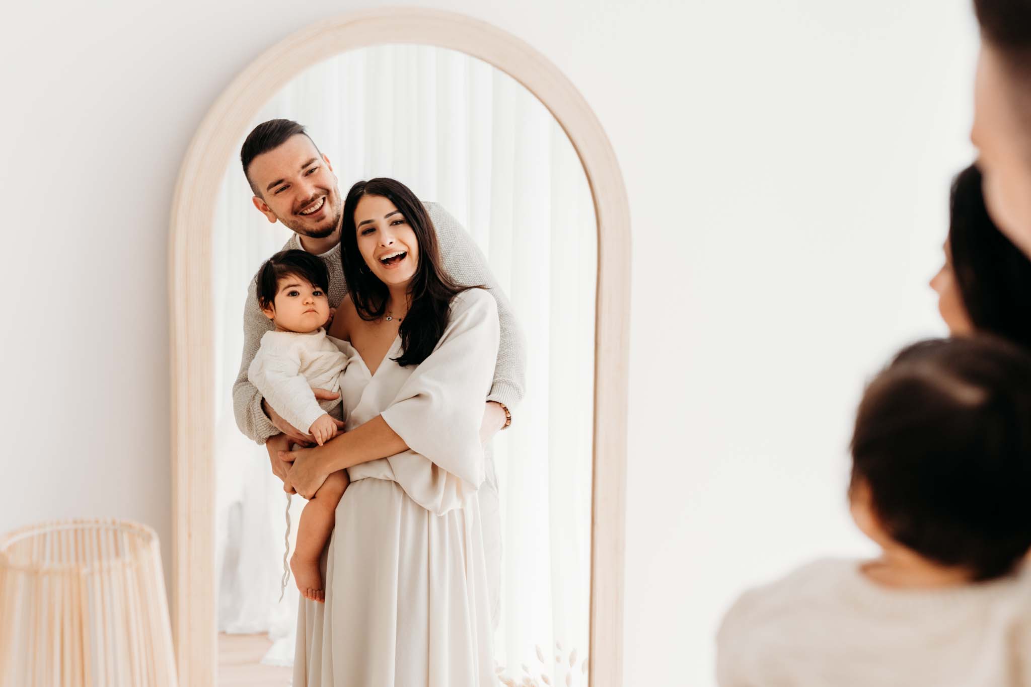 Familiefoto vor demm Spiegel und lächeln sich gegenseitig an