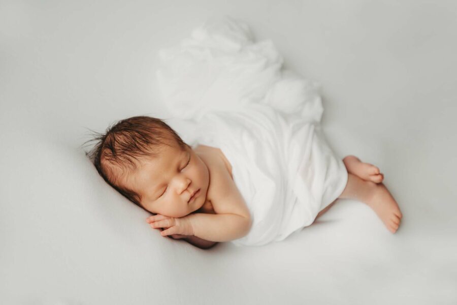 Babyfotografie puristisch, weiß, clean - Side Pose Baby liegt auf der Seite